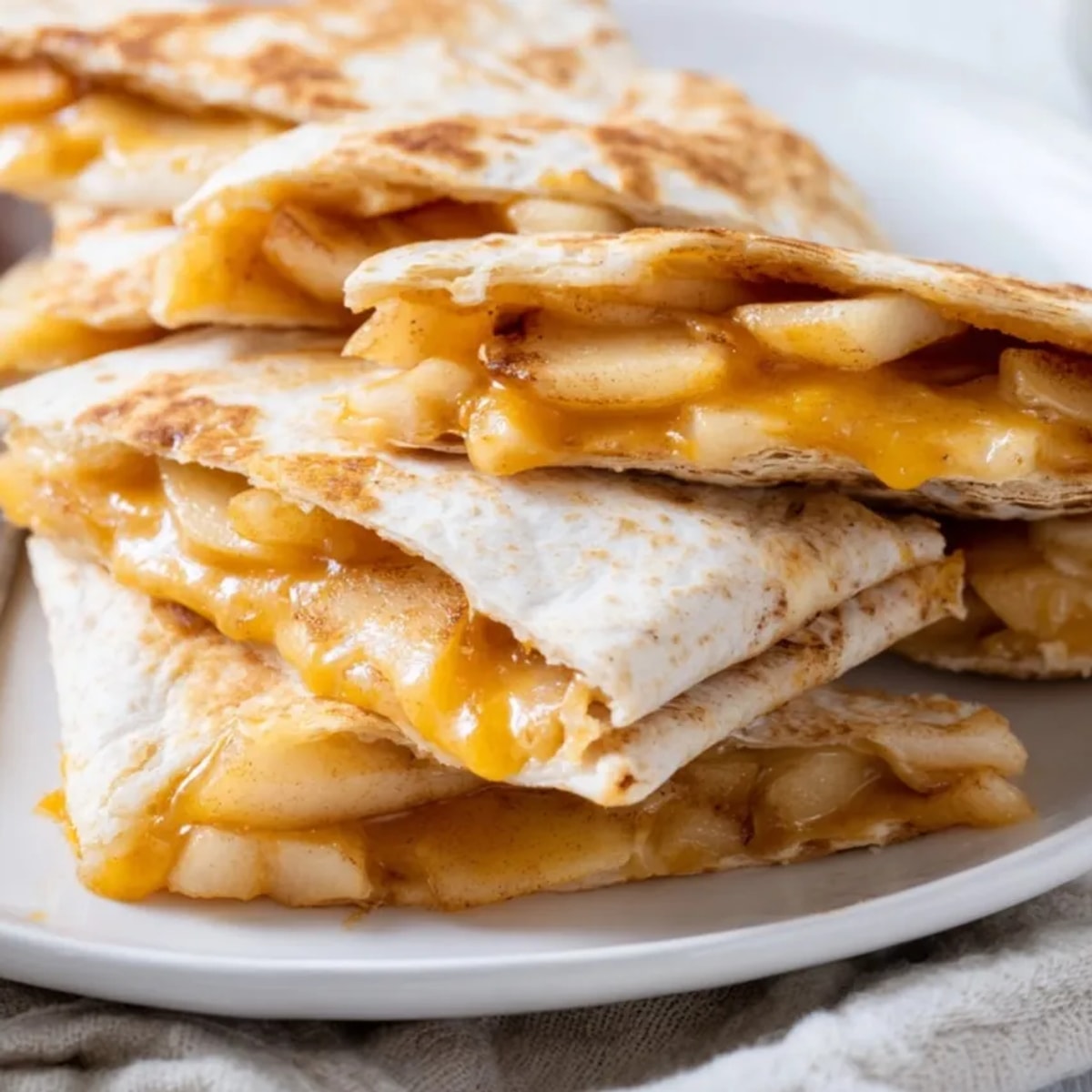 Golden Cheddar Apple Quesadillas, warm from the skillet, ready to enjoy as a snack.