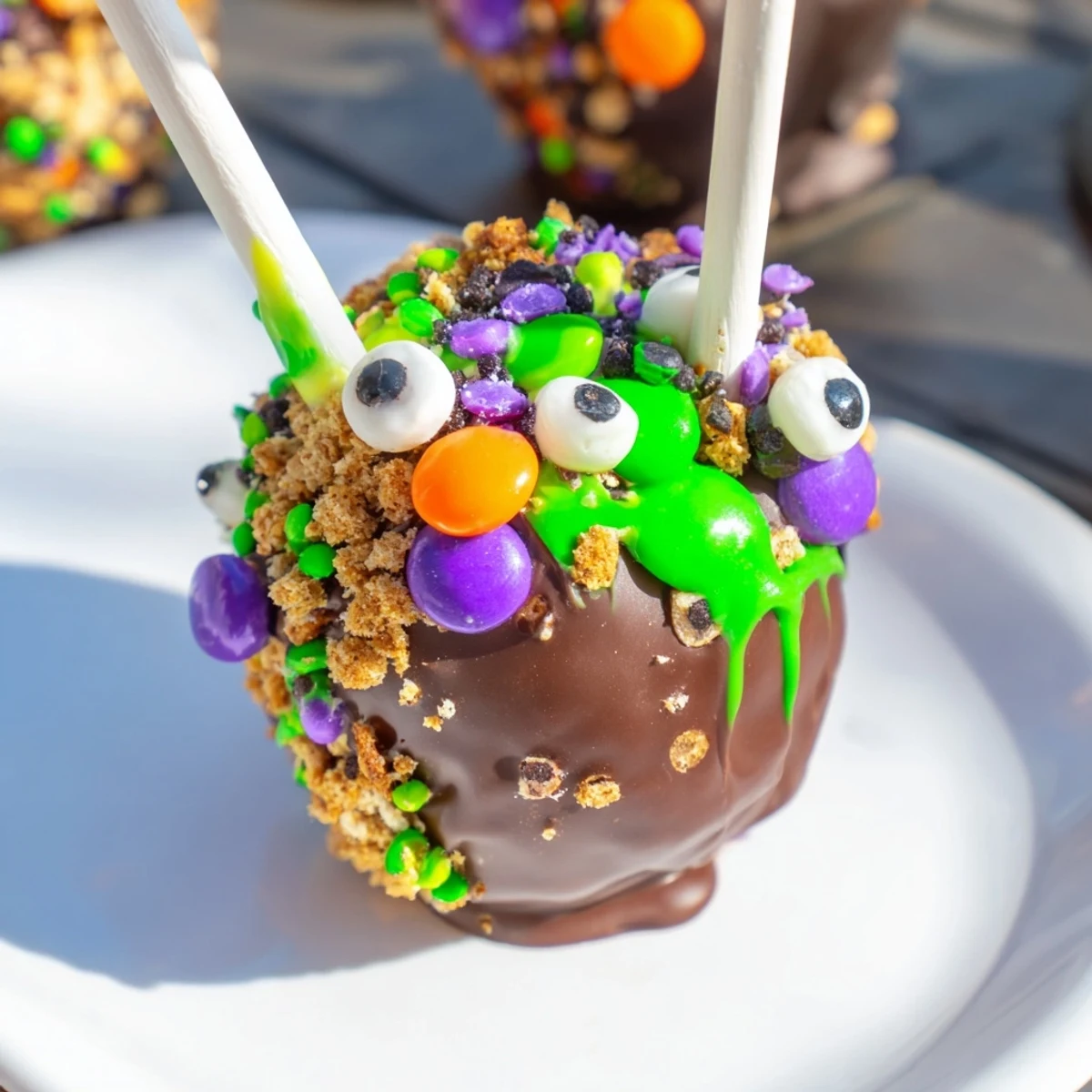 Colorful Monster Chaos Cake S'mores Pops coated in melted chocolate and sprinkles.  