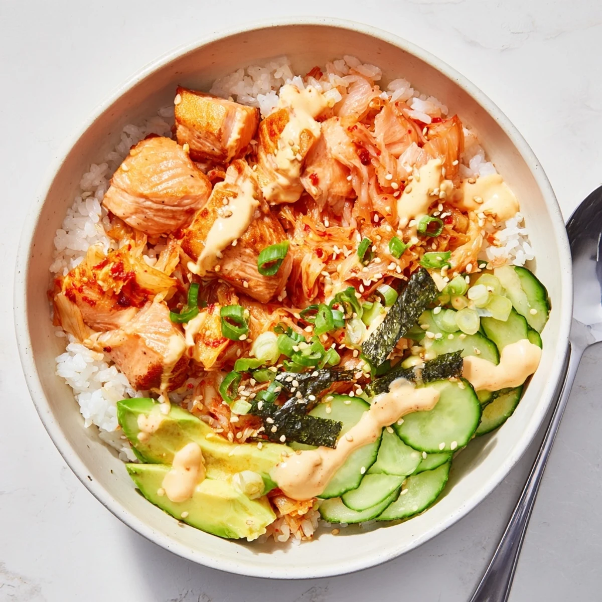 A colorful Crispy Salmon Rice Bowl topped with spicy mayo and fresh avocado.  