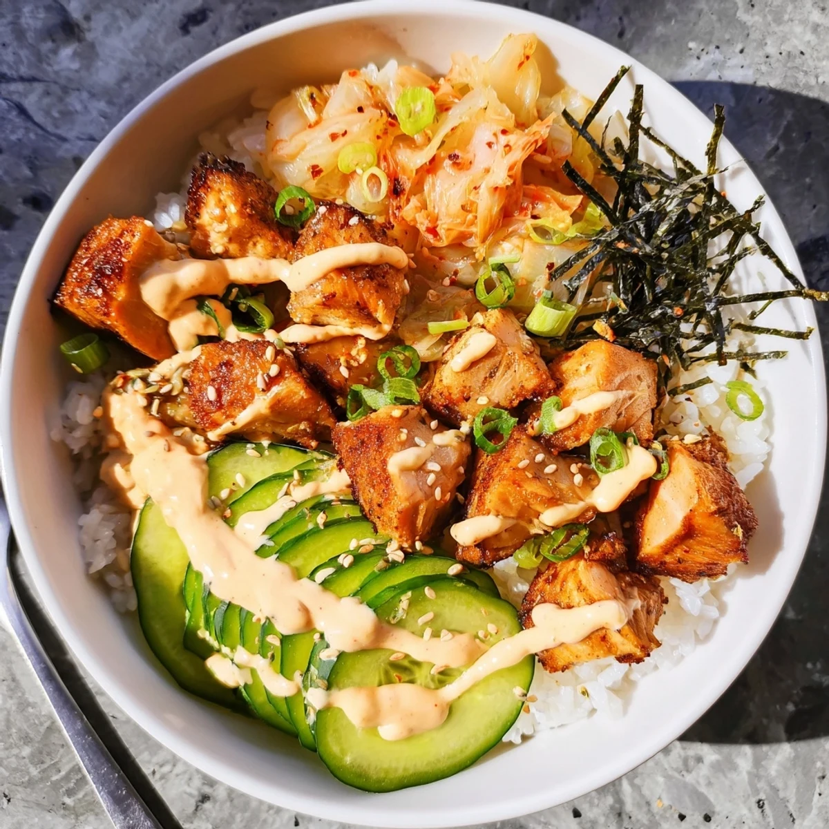 Savory Crispy Salmon Rice Bowl garnished with garlic, scallions, and toasted sesame seeds.