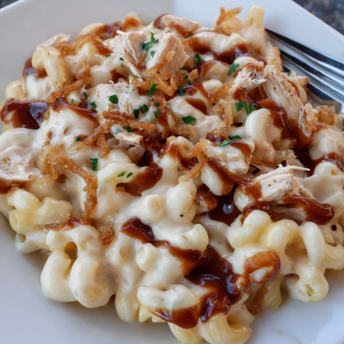 A comforting bowl of One-Pot Honey BBQ Chicken Mac and Cheese, drizzled with honey.