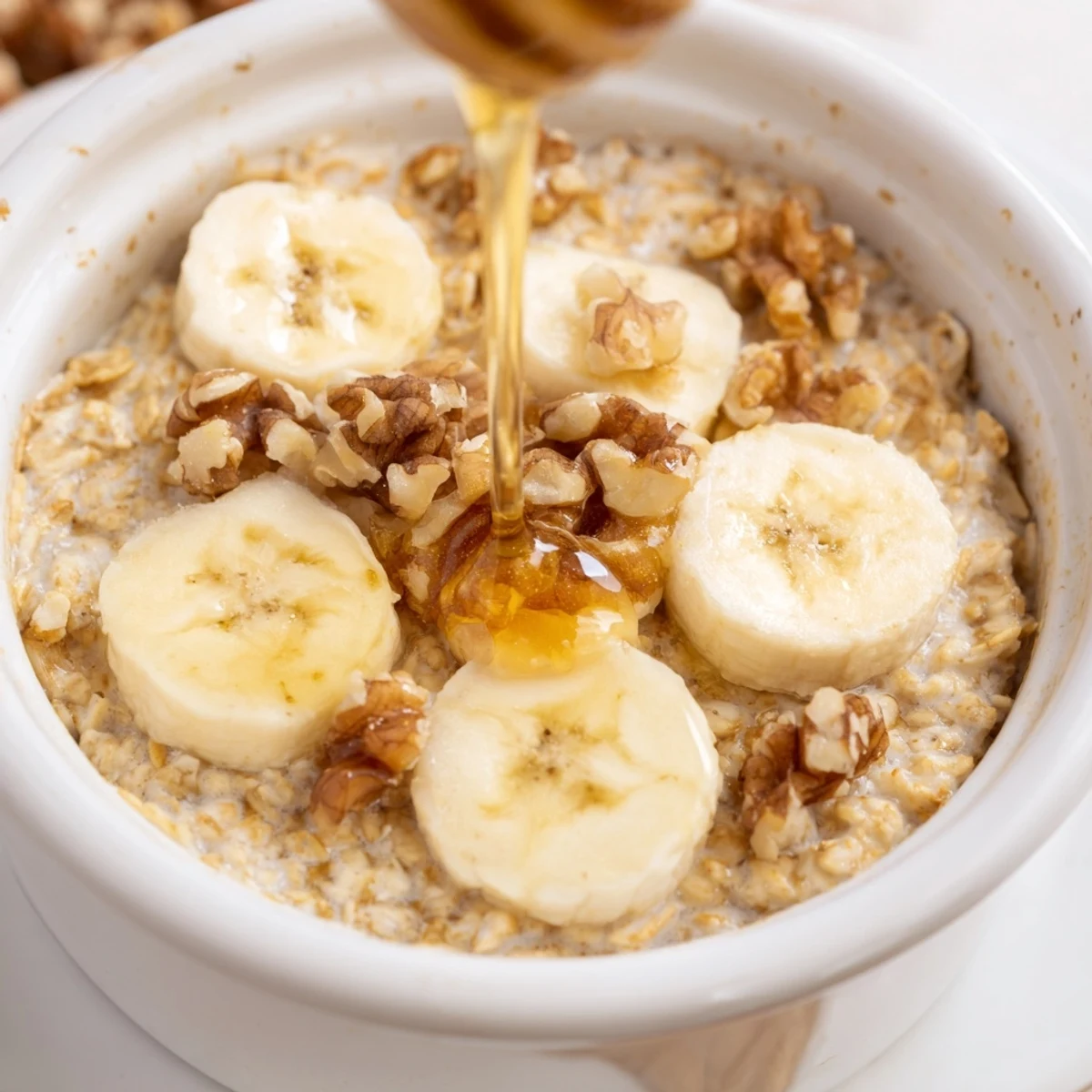 Warm, individual servings of baked oats ramekins, studded with banana and glistening with honey.