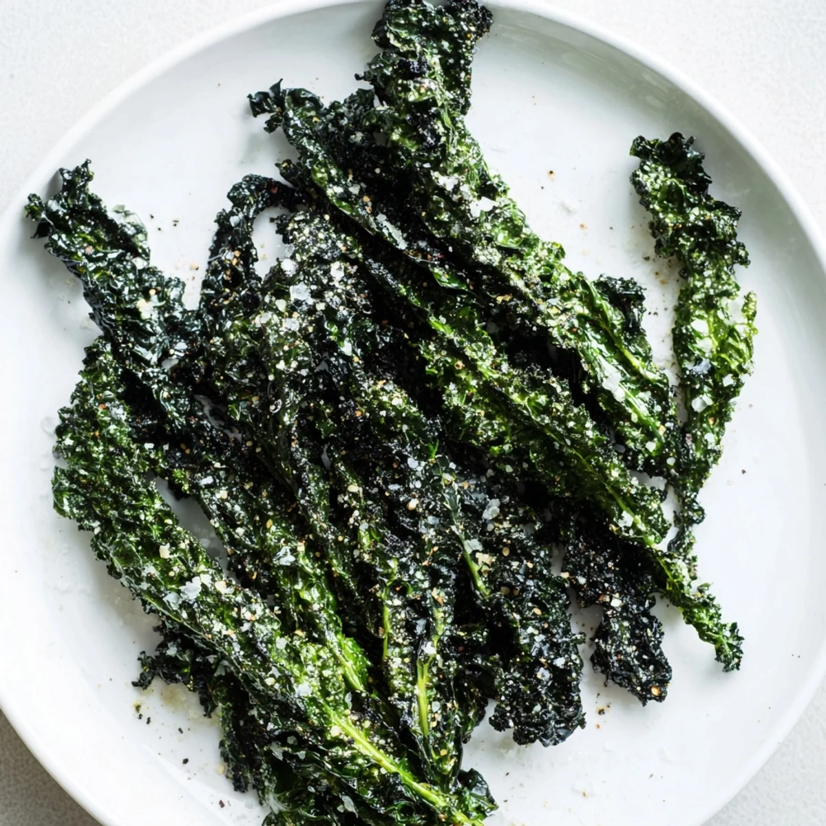 Close-up of freshly baked kale chips, perfectly seasoned and lightly salted, ready to crunch.