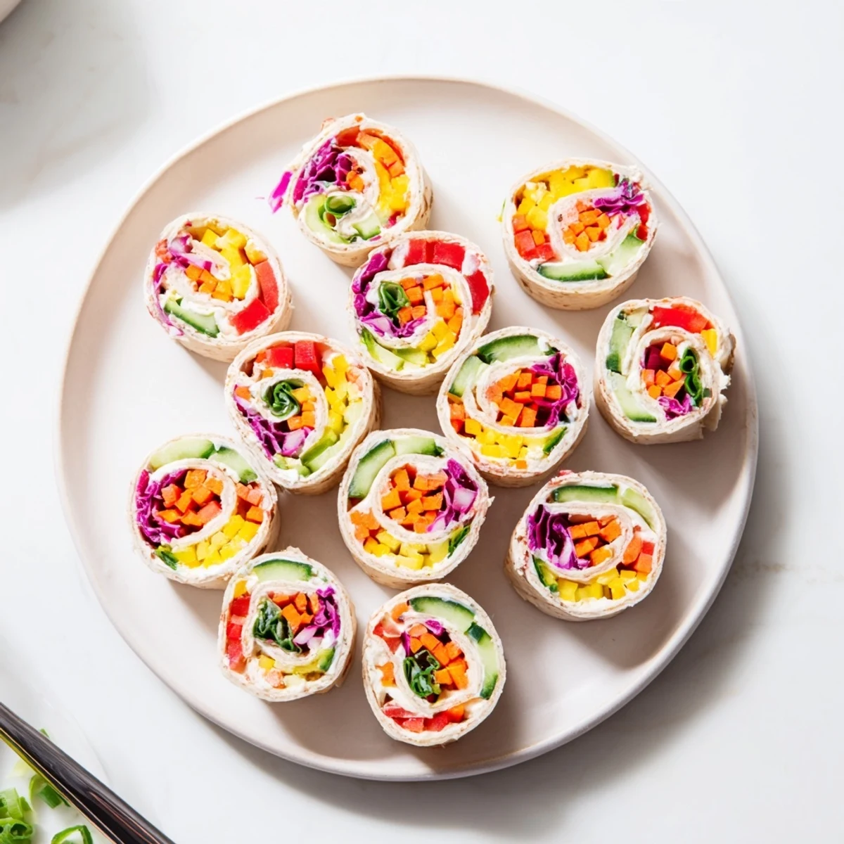 Delicious Rainbow Veggie Christmas Lights Wrap Pinwheels displayed on a platter, perfect for a healthy and visually stunning holiday snack.