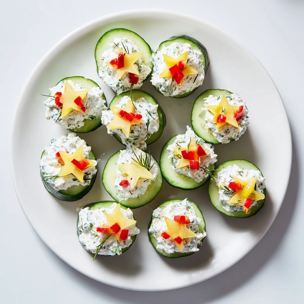 Holiday Star Cucumber Bites, a colorful, refreshing appetizer with vibrant pepper and dill toppings.