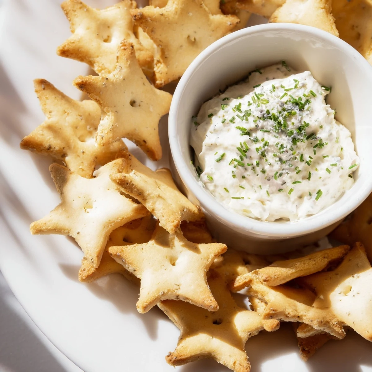 Crispy Holiday Crackers feature a star shape, perfectly complementing the creamy herb dip in the middle.