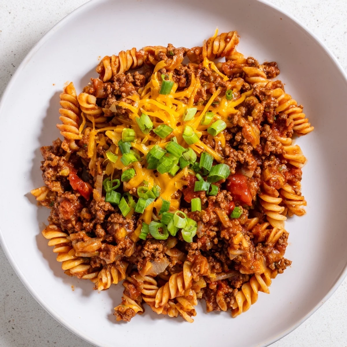 One-Pot Taco Pasta, a bubbling skillet filled with ground beef and melted cheese.