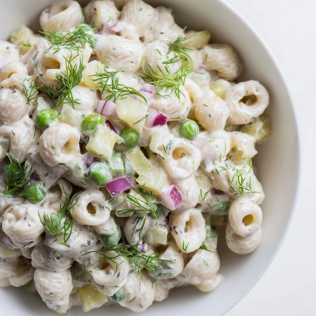Side view of vegetarian dill pickle pasta salad, perfect for spring picnics and potlucks, with a tangy creamy texture.