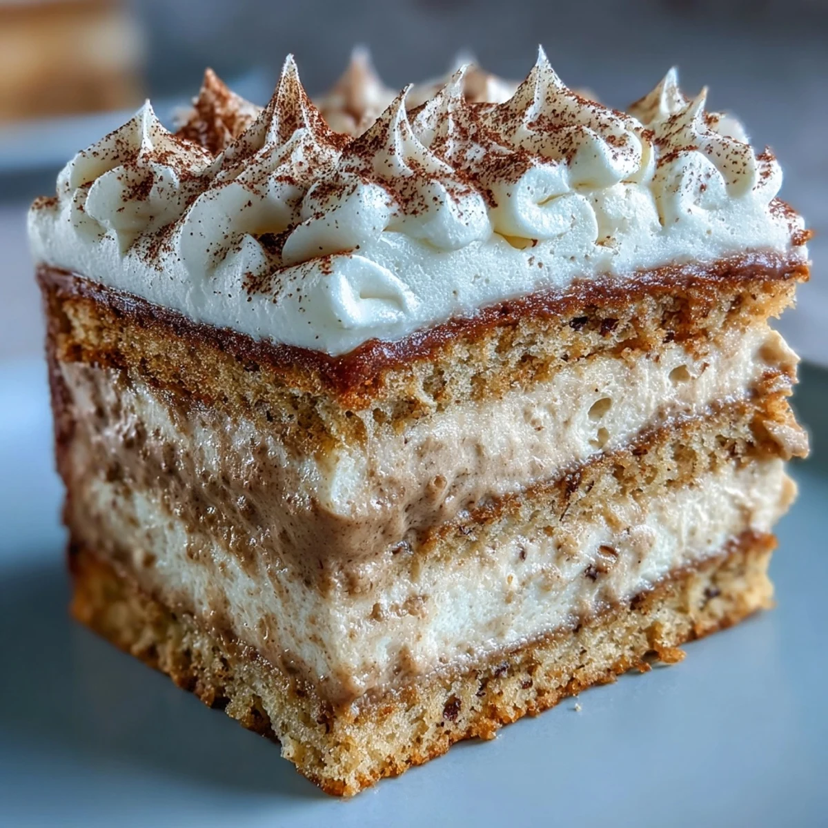 Fluffy Hojicha Cake slice showing airy genoise layers and rich, creamy hojicha filling plated with matcha.