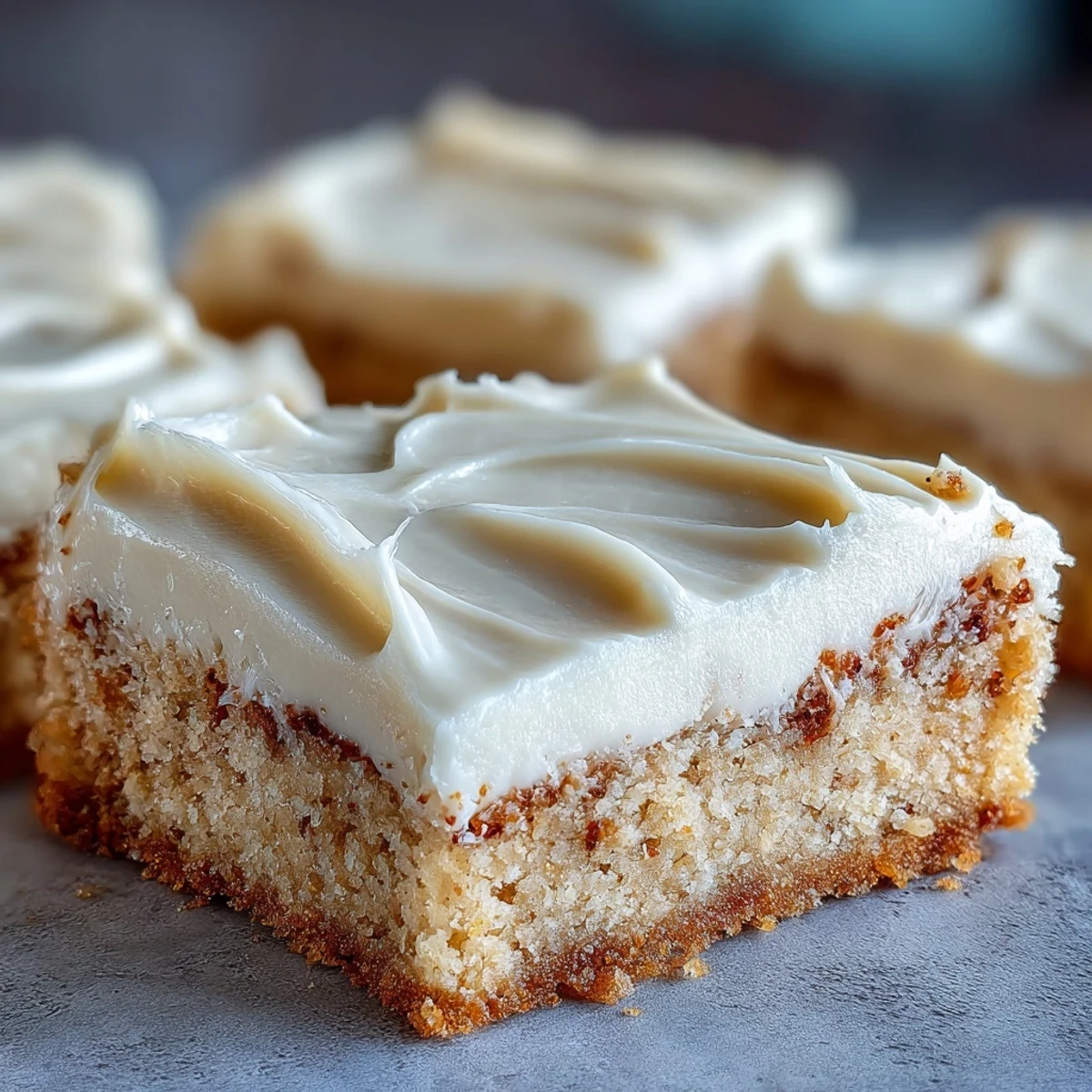 Golden-brown Almond Flour Sugar Cookie Bars cooling on a wire rack, topped with creamy frosting.