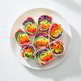 Close-up of Rainbow Veggie Christmas Lights Wrap Pinwheels: fresh, rolled wraps sliced, featuring festive veggie patterns, perfect party food.