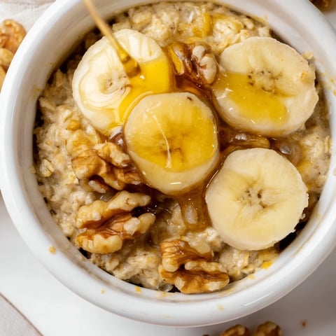 Golden-brown baked oats ramekins with banana slices and a honey drizzle for a perfect breakfast.