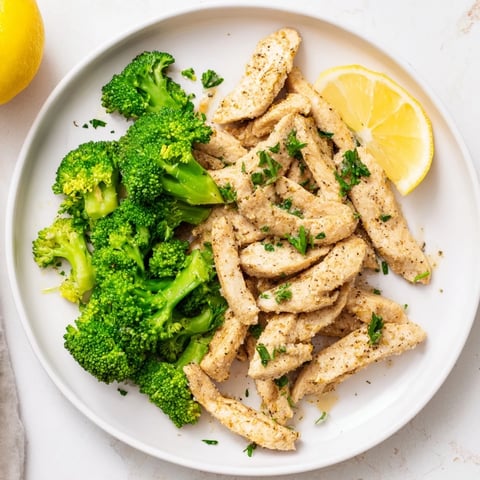 Tender Microwave-Steamed Chicken and Broccoli, glistening with olive oil and seasoned with paprika.