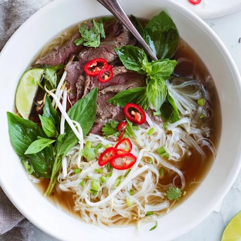 Steaming hot Vietnamese Pho express, filled with tender beef, rice noodles, and fresh, fragrant herbs.