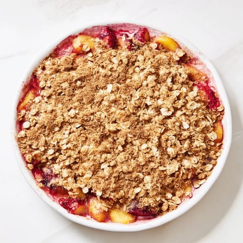 Sweet, bubbly Fruit Crisp, showcasing the vibrant colors of mixed frozen fruit and a crumbly oat topping.