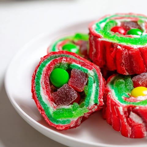Close-up of freshly made Easy Christmas Fruit Rollup Sushi rolls glistening with sprinkles and candies, delicious!