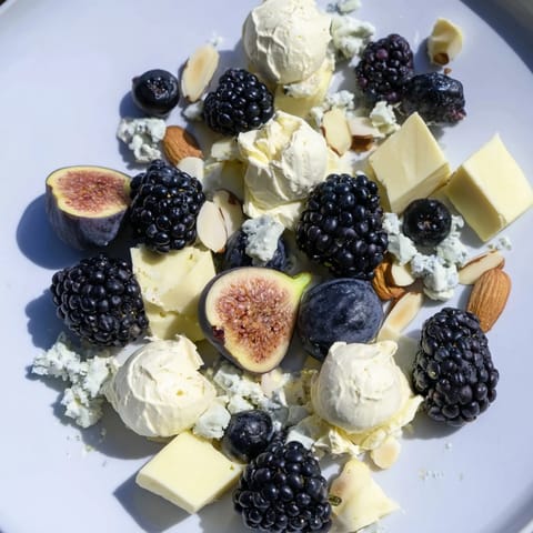 This Deep Indigo Midnight Sky cheese board showcases dark fruits, cheeses, and crackers ready for serving at a party.