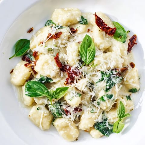 Warm, comforting Creamy Tuscan Gnocchi garnished with fresh basil, ready to serve, Italian inspired.