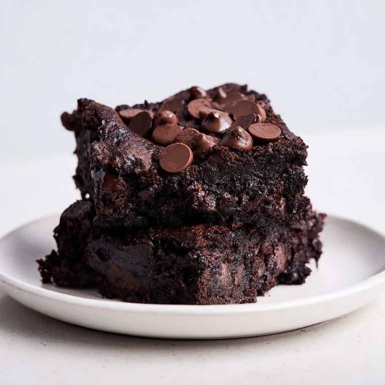 A close-up of a pan of fudgy Black Bean Brownies, showcasing a rich dark chocolate color.