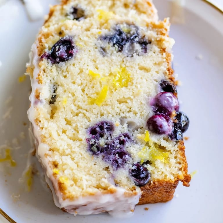 Freshly baked Lemon Blueberry Yogurt Loaf with a tender crumb and drizzled lemon glaze served.